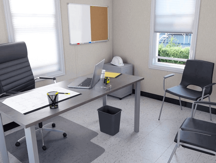 Modern office interior featuring a desk, ergonomic chair, and modular furniture design, showcasing a triumph modular approach to temporary modular building solutions.