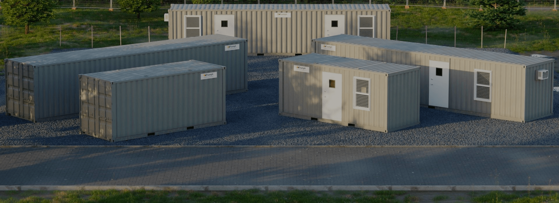 View of several triumph modular buildings arranged on a gravel surface, showcasing a temporary modular building setup for various uses in modular construction.