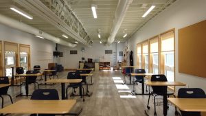 Interior view of a classroom in a triumph modular building, showcasing a spacious layout with desks and natural lighting, illustrating the benefits of modular construction for educational settings.