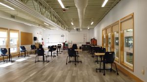 Modern classroom setup featuring desks and chairs in a permanent modular building, showcasing the flexibility of modular construction for educational spaces.