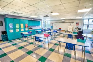 Bright and spacious classroom featuring blue and green decor, showcasing a triumph modular design for modular construction, ideal for permanent or temporary modular building solutions.