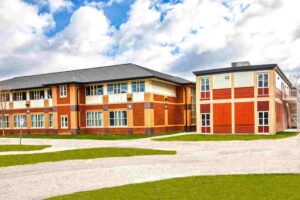 Triumph modular building showcasing modern architectural design with a combination of red and beige brick exteriors, ideal for permanent modular construction.