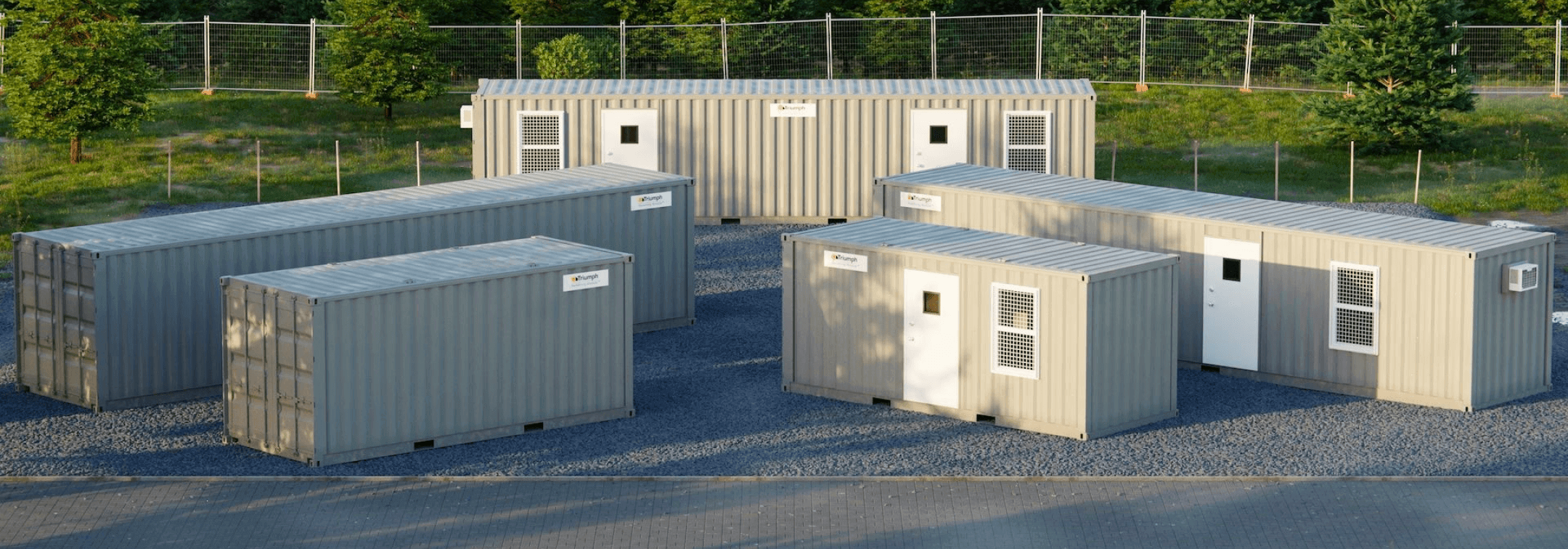 A cluster of triumph modular buildings arranged on a gravel surface, showcasing various configurations of temporary modular construction.